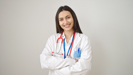 Young beautiful hispanic woman doctor smiling confident standing with arms crossed gesture over isolated white background