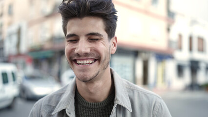 Fototapeta premium Young hispanic man smiling confident standing at street