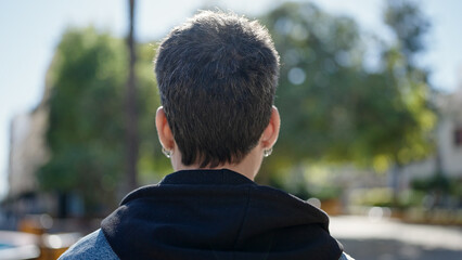 Fototapeta premium Young hispanic man standing backwards at park