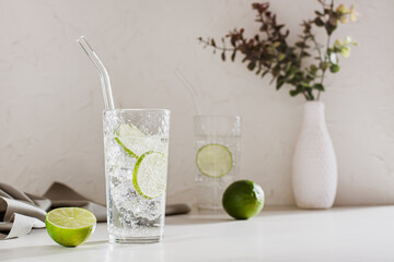 Sparkling mineral water with ice and lime in glasses for refreshment in the summer heat