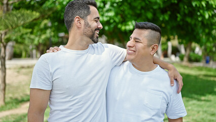 Fototapeta premium Two men smiling confident hugging each other at park