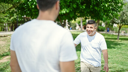 Two men smiling confident standing together at park