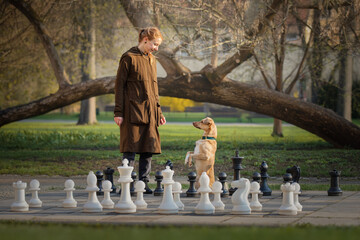 Beautiful girl and little red dog and big chess