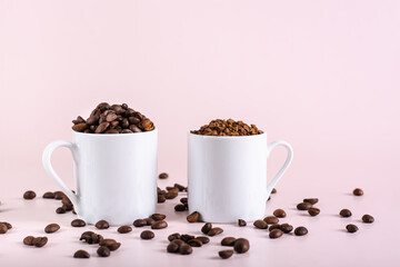 Roasted coffee beans and instant coffee in cups on pink background
