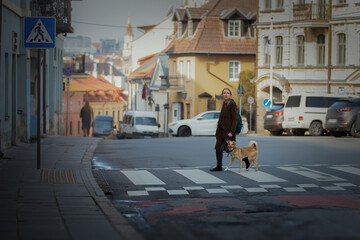 Beautiful blonde girl with dog in the city