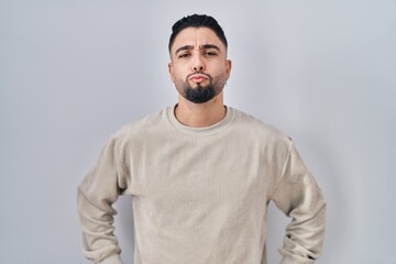 Young handsome man standing over isolated background looking at the camera blowing a kiss on air being lovely and sexy. love expression.