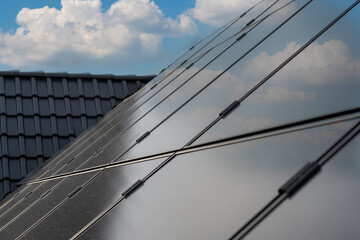 Diese PV-Anlage auf dem Dach einer modernen Wohnanlage nutzt die Kraft der Sonne, um erneuerbare Energie zu erzeugen. Die Solarpanels fangen das Sonnenlicht ein und wandeln es in saubere, grüne Energi - obrazy, fototapety, plakaty