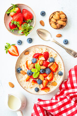 Oatmeal porrige with fresh berries and nuts. Healthy breakfast, top view.