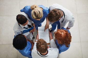 Above, doctor group and paperwork in a hospital and clinic with teamwork and collaboration. Medical...