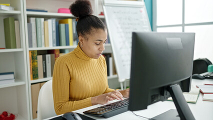 Young african american woman student using computer studying at the library