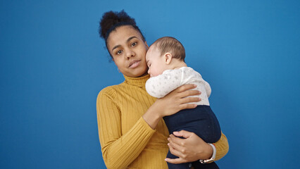 Obraz premium Mother and son hugging each other over isolated blue background