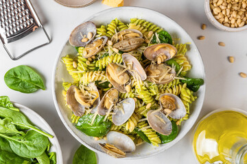 Seafood pasta with clams vongole, parmesan cheese, spinach, pine nuts and olive oil. Top view