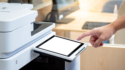Male hand touching button on photocopier monitor screen, copying and printing paperwork in the...