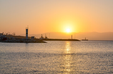 Fototapeta na wymiar Cesme harbor lighthouse at sunset (Izmir province, Turkiye)
