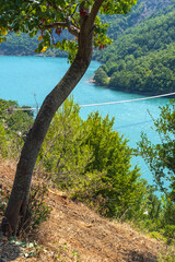 View from one of most beautiful roads in Albania along the Shkopet Lake precipitous сoast. Shkopet wooden pedestrian Bridge, Lake Ulza Nature Park, Diber County, Balkan mountains, Albania, Europe.