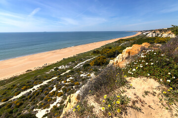 Fototapeta na wymiar One of the most beautiful beaches in Spain, called (Arenosillo, Huelva) in Spain. Surrounded by dunes, vegetation and cliffs. A gorgeous beach.