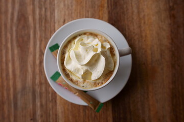 Cream cappuccino in a small cup and saucer, drinking a strong cup of coffee, prepared by a trained barista at a wild life reserve overlooking the animals in the bush veld 