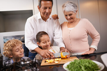 Food, grandparents or happy kids learning cooking skills for a healthy dinner with fruit or vegetables at home. Teaching, child development or grandmother with old man or meal nutrition in kitchen