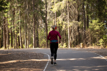 Obraz premium A young woman runs around the spring park.Outdoor activity.