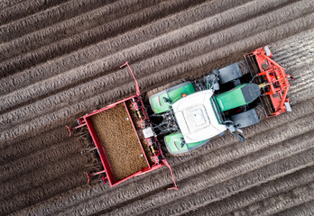 Drohnenfoto - Kartoffelanbau mit moderner Landtechnik - Traktor mit Kartoffellegemaschine.