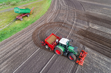  Luftbild. Traktor mit Kartoffelpflanzmaschine aus der Vogelperspektive, im Hintergrund der Anhänger mit den Pflanzkartoffeln.