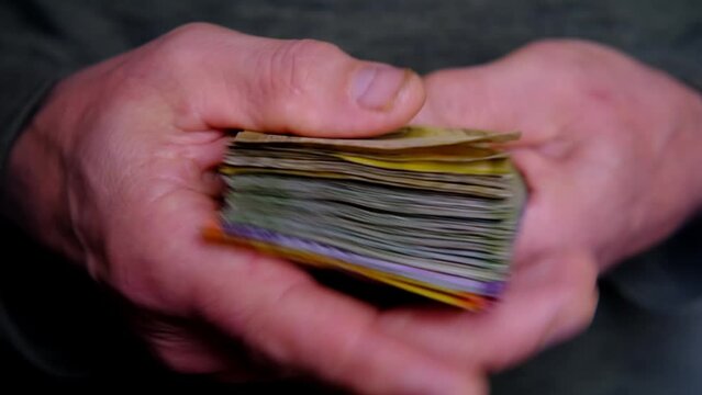 man holds, counts lot of national currency of Sri Lanka, paper money bills Rupee banknotes, devaluation, high inflation of state, exchange rate on travel, vacation, savings, banking, tax payment