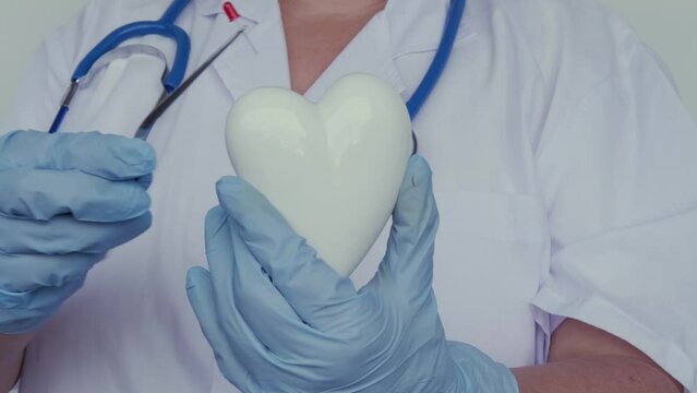 female scientist, doctor holding heart model, microprocessor, microchip, biochip tweezers for immunocytochemical studies heart, treatment cardiovascular disease, experimental nanotechnology medicine
