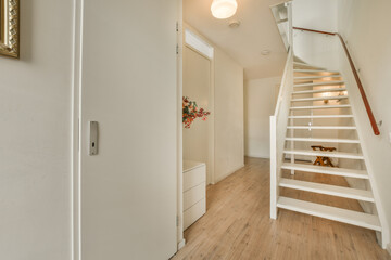 a room with wooden floors and a white staircase leading up to the second floor there is a mirror on the wall