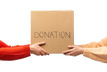 charity and volunteering concept - hands holding cardboard box with donations isolated on white...