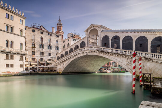Rialto Bridge and the Grand Canal Venice Italy. Sunny day long exposure has smoothed the canal. No people in the photograph of this famous Venetian landmark. 