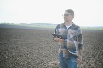 A farmer checks quality of soil before sowing.