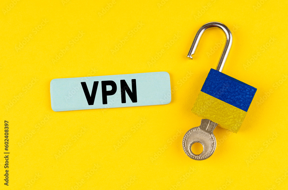 Poster on the yellow surface is an open lock with a key and a sticker with the inscription - vpn
