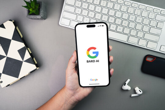 Girl holding a smartphone with Google Bard AI artificial intelligence chatbot app on the screen on grey background table. Office environment. Rio de Janeiro, RJ, Brazil. May 2023