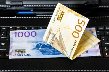 Norwegian krone lying on tablet keyboard, Norway e-commerce business, Shopping and trading, Online...