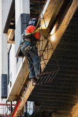 Naklejka premium Vertical Shot of Construction Worker Welding High Above in a Basket
