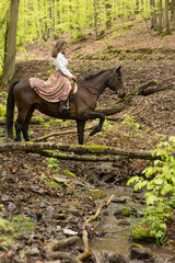 Frau reitet im Fr&uuml;hling im Wald