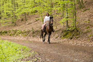 Frau reitet im Frühling im Wald