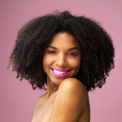 Hair care, face and happy black woman with makeup in studio isolated on a pink background for skincare. Hairstyle portrait, beauty cosmetics and African female model with salon treatment for afro.