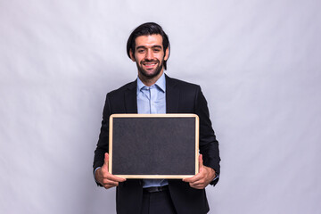 Businessman holding chalk board on white background. Handsome businessman holding black board. Handsome man holding small framed blackboard