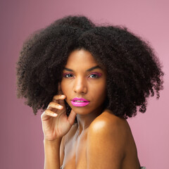 Face, hair care and serious black woman with makeup in studio isolated on a pink background for skincare. Hairstyle portrait, cosmetics and African female model with salon treatment for afro beauty.