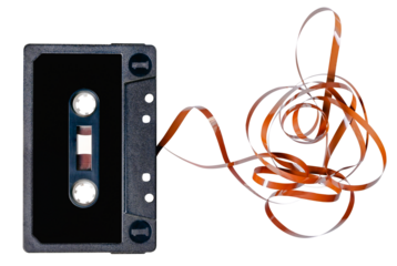Old audio cassette with unrolled tape. Isolated background.