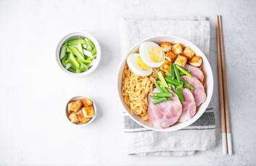 Ramen noodle with meat slices, fried Tofu, eggs and scallions in a bowl