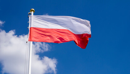 Naklejka na ściany i meble Polish flag against the sky