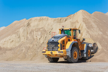 Fototapeta na wymiar Wheel loaders moving sand in a quarry.
