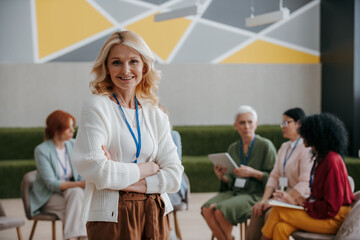 Fototapeta premium Happy mature woman looking at camera while visiting group training class for females