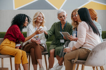 Group of happy mature women examining beauty products during specialized conference