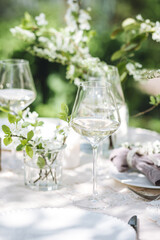 Rustic elegant eco friendly zero waste trendy wedding reception table decor with fresh spring apple cherry flowers in bloom. Beautiful marriage decoration, holiday event outdoors in the family garden