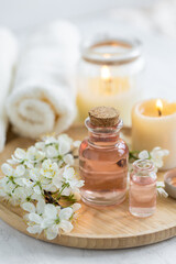 Concept of pure natural organic ingredients, flowers, herbal extracts in cosmetic beauty products. Perfumery, home fragrance with the scent of blooming spring flowers. Candles, bamboo tray