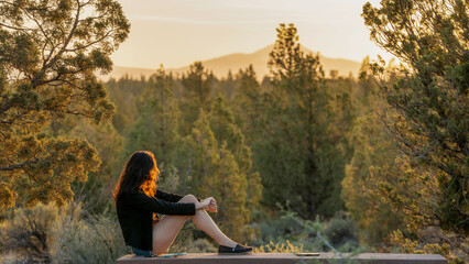 Woman Watches as the Sun Sets Over the Cascades in Bend Central Oregon