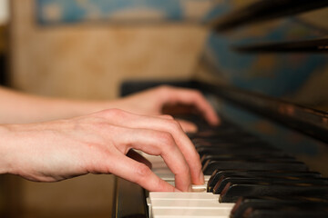 A girl plays the piano at home. Close-up